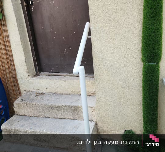 מעקה לבן ליד דלת חומה ומדרגות אבן